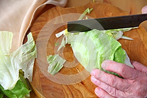 Man cuts up lettuce wedge