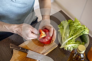 Man cuts vegetables in the kitchen to prepare a vegetarian dish. Family lifestyle