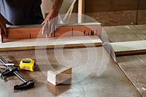 A man cuts wood on a circular saw in a carpenter workshop