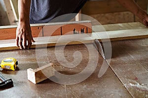 A man cuts wood on a circular saw in a carpenter workshop