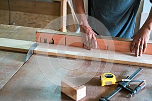 A man cuts wood on a circular saw in a carpenter workshop