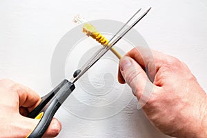 Man cuts yellow network internet cable on white background