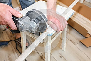 Man is cutting baseboard. Repair works indoors. Renovation in the flat.  Angle grinder in hands