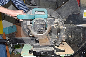 Man cutting a board with a miter saw