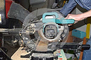 man cutting a board with a miter saw