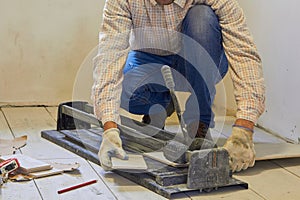 a man is cutting ceramic tiles in the room,laying tiles, the work of a tiler builder