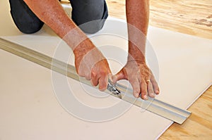 Man cutting drywall with utility knife