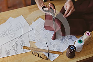 Man cutting fabric with scissors on table