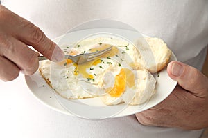 Man cutting into fried eggs