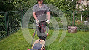 Man cutting grass with corded electric lawn mower