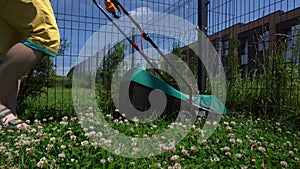 Man cutting grass in his house garden yard with lawn mower. Gimbal movement