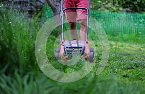 A man cutting the grass with a lawn mower