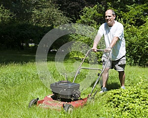 Man cutting grass at suburban house