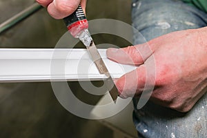 Man is cutting gypsum baseboard with utility knife. Maintenance repair works renovation in the flat . Restoration indoors. Drywall