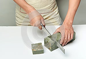 Man cutting a handmade soap with a knife