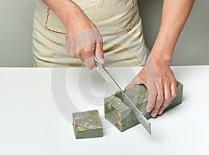 Man cutting a handmade soap with a knife
