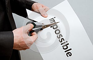 Man cutting inscription on a paper with scissors