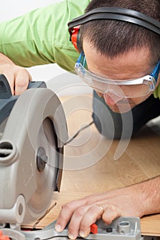 Man cutting laminate floor plank