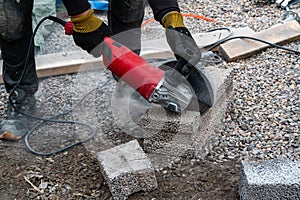 Man cutting light weigt cinder block with angel grinder