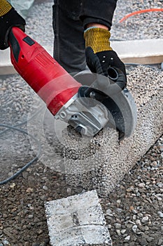 Man cutting light weigt cinder block with angel grinder