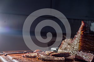 man cutting and manipulating a piece of smoked brisket, with natural light and copy space
