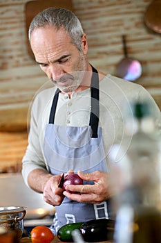 Man cutting an oignon in kitchen