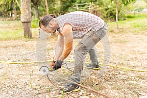 Man cutting a piece of iron using a radial saw