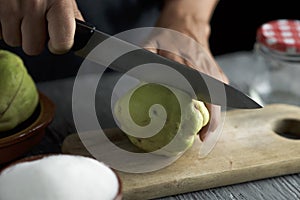 Man cutting a quince fruit with a knife