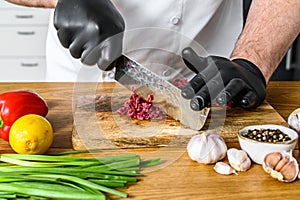 Man cutting raw beef meat. A chef in black gloves. Concept of cooking beef tartare