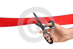 Man cutting red ribbon on white background, closeup