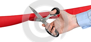 Man cutting red ribbon on white background, closeup