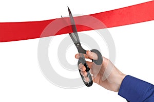 Man cutting red ribbon on white background, closeup