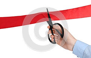 Man cutting red ribbon on white background, closeup