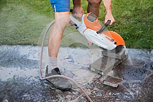 Man cutting stone tiles with a circular saw