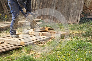 Man cutting wood with chainsaw close up