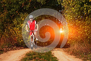 Man is cycling in autumn forest