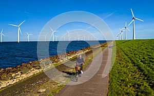 A man is cycling down a serene path next to the lake ijsselmeer n Flevoland, Netherlands.