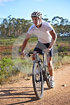 Man, cycling and exercise on bike in nature for journey and adventure in countryside. Athlete, workout and person riding