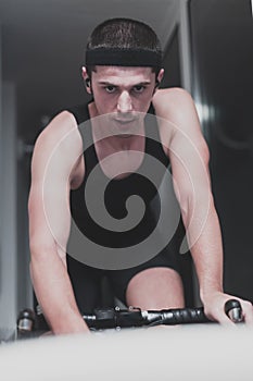 Man cycling on the machine trainer he is exercising in the home at night playing online bike racing game