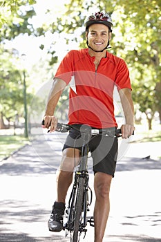 Man Cycling Through Park