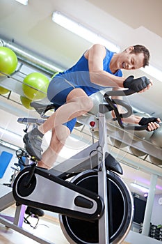 Man cycling on spinning bike with great effort