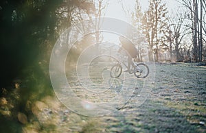 Man cycling in a sunlit park during afternoon, enjoying a relaxed outdoor ride