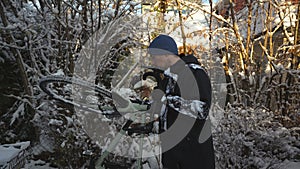 Man cyclist brushes his bicycle in the backyard in winter before taking it into the parking garage. Winter cycling and