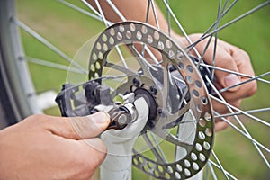 Man cyclist checks brake wheel of bicycle