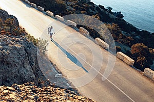 Man cyclist pedaling on a road bike outdoors in sun set