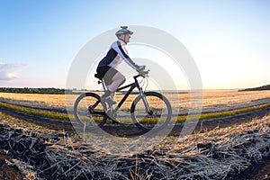 man cyclist rides a bike on a road in nature. sports, cycling and health hobbies