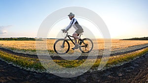 man cyclist rides a bike on a road in nature. sports, cycling and health hobbies