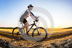 man cyclist rides a bike on a road in nature. sports, cycling and health hobbies