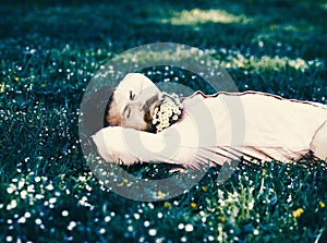 Man with daisy flowers in beard lay on meadow, grass background. Man with beard on smiling face enjoy nature. Relaxation