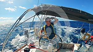 A man is dancing while managing a yacht in the ocean